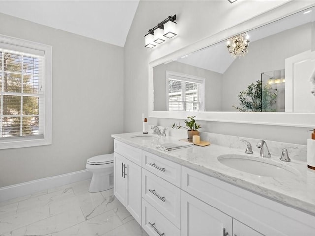 bathroom with a notable chandelier, vaulted ceiling, vanity, and toilet