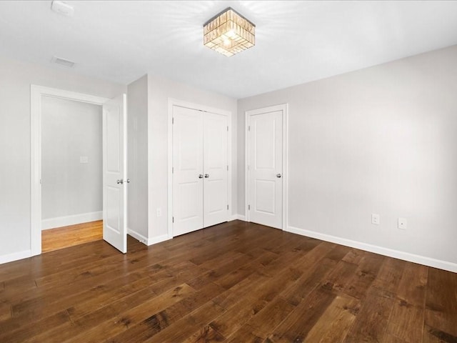 unfurnished bedroom featuring dark wood-type flooring and a closet