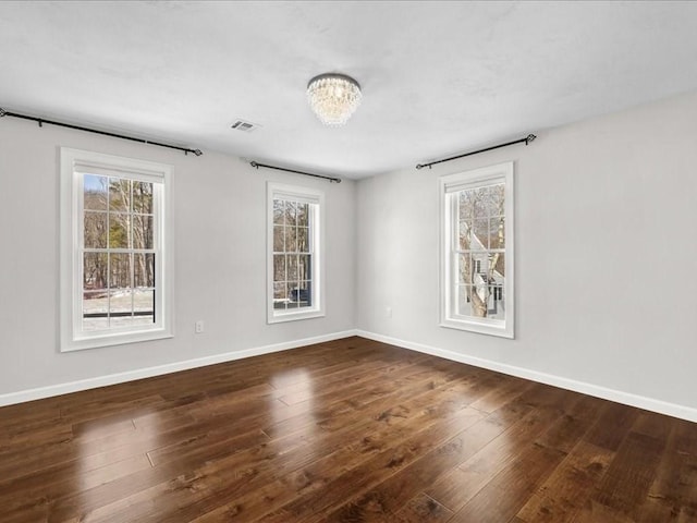 unfurnished room featuring dark hardwood / wood-style flooring and plenty of natural light