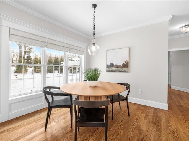 dining area with ornamental molding, wood-type flooring, and a healthy amount of sunlight