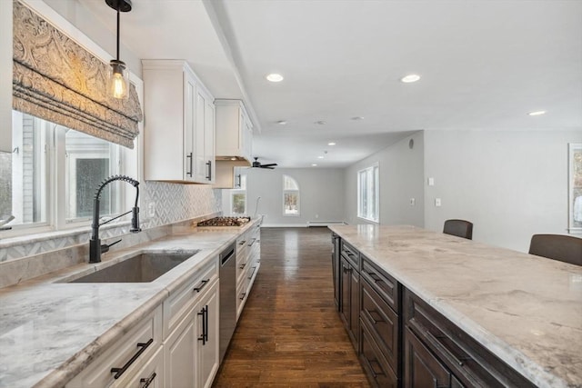 kitchen with hanging light fixtures, white cabinetry, appliances with stainless steel finishes, and sink