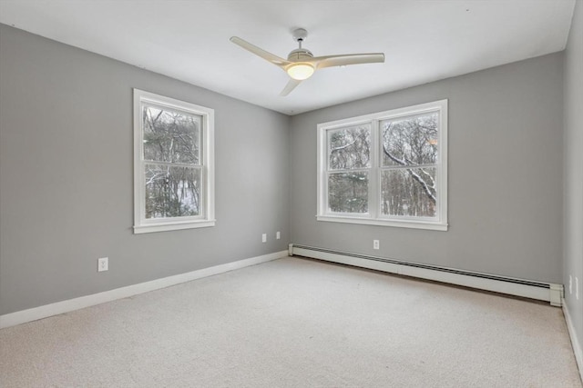 empty room featuring ceiling fan, a baseboard radiator, light colored carpet, and a healthy amount of sunlight