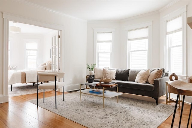 interior space featuring light wood-type flooring, crown molding, and baseboards