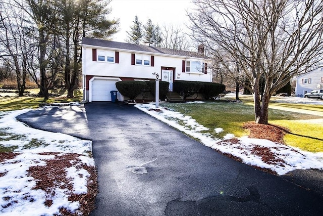 split foyer home with a garage and a lawn