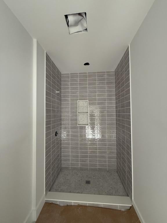 bathroom with tile patterned flooring and tiled shower