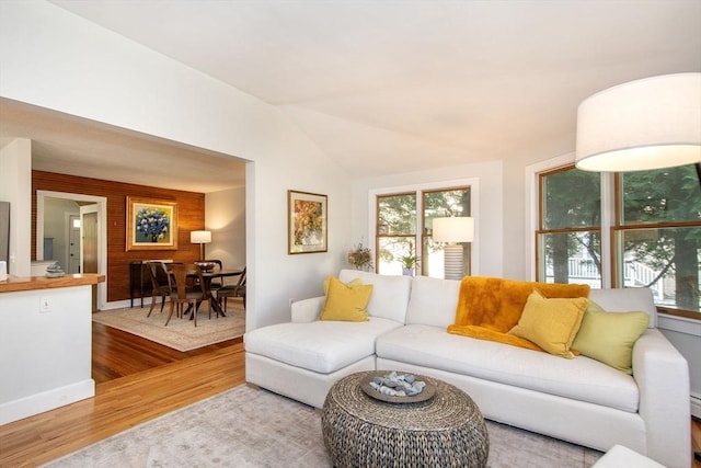 living room with wood finished floors, wooden walls, and vaulted ceiling