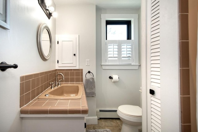 bathroom with baseboard heating, toilet, vanity, and baseboards