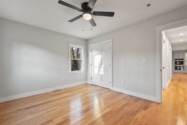 unfurnished room featuring light hardwood / wood-style flooring and ceiling fan