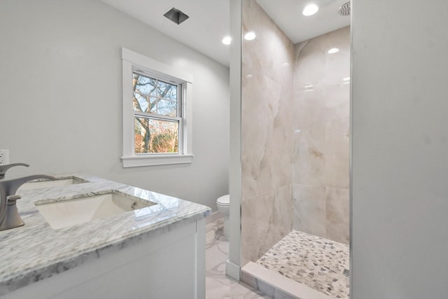 bathroom featuring tiled shower, vanity, and toilet