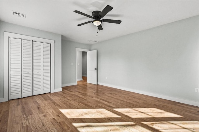 unfurnished bedroom featuring ceiling fan, a closet, and wood-type flooring