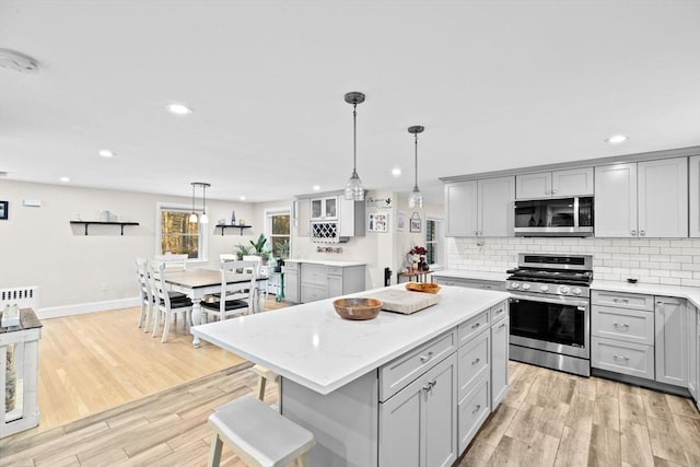 kitchen featuring pendant lighting, appliances with stainless steel finishes, and gray cabinets