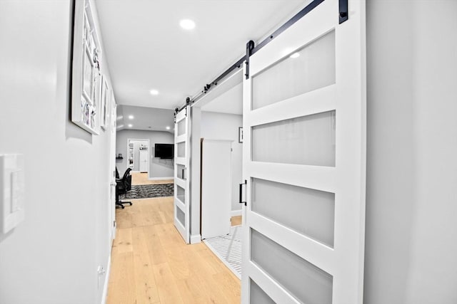 corridor featuring a barn door and hardwood / wood-style floors