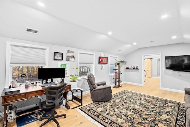 office space featuring vaulted ceiling and light hardwood / wood-style flooring