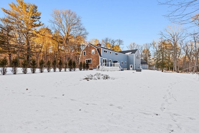 view of snow covered back of property