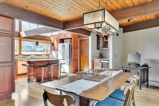dining space featuring beamed ceiling, light wood-style floors, and wood ceiling