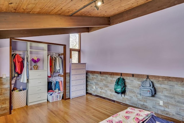 bedroom featuring wood ceiling, wood finished floors, beamed ceiling, and a closet