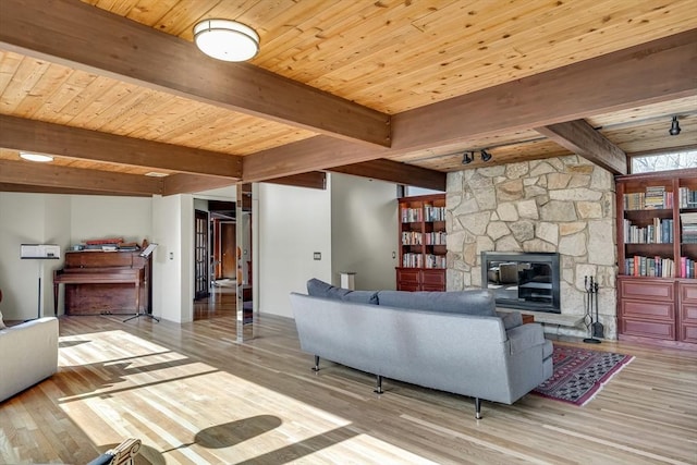 living area with wooden ceiling, beamed ceiling, wood finished floors, and a fireplace