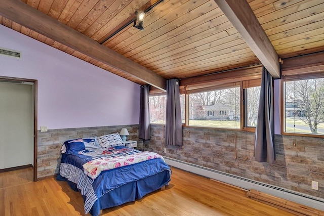 bedroom with beamed ceiling, a baseboard radiator, visible vents, wooden ceiling, and wood finished floors