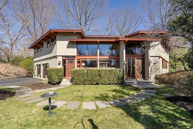 view of front of house with a front lawn, driveway, and an attached garage