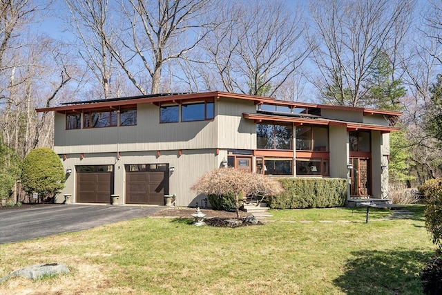 view of front of house featuring a front yard, driveway, and a garage