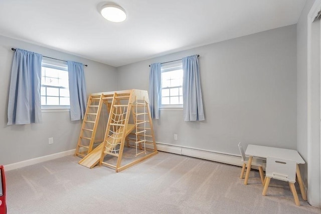 bedroom with a baseboard radiator, carpet floors, and multiple windows