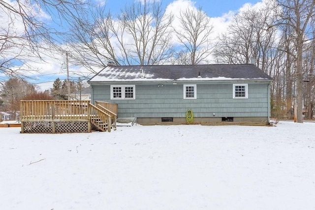 snow covered house with a deck