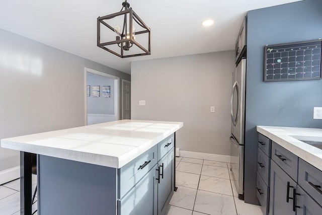 kitchen featuring pendant lighting, stainless steel fridge, gray cabinetry, a center island, and a barn door