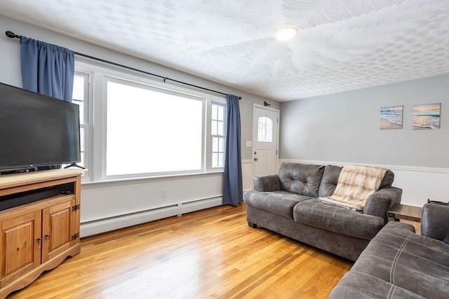 living room with light hardwood / wood-style floors, a textured ceiling, and a baseboard heating unit