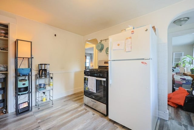 18-20 Melbourne Ave, Newton, MA 02460 - kitchen featuring freestanding refrigerator, gas stove, arched walkways, and wood finished floors