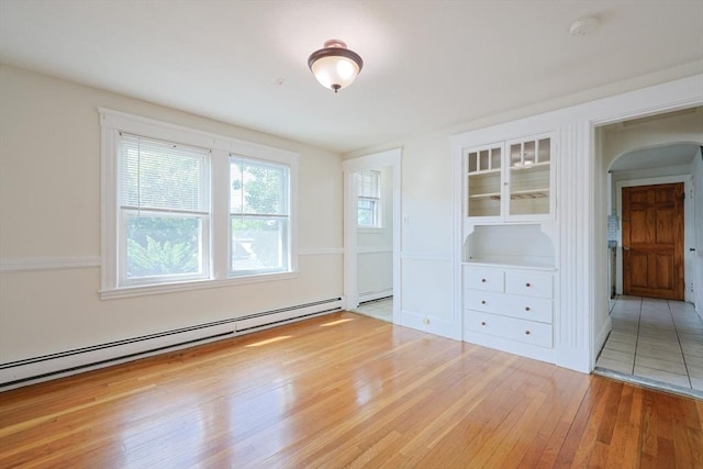 18-20 Melbourne Ave, Newton, MA 02460 - spare room with wood-type flooring, arched walkways, a baseboard radiator, and a smoke detector