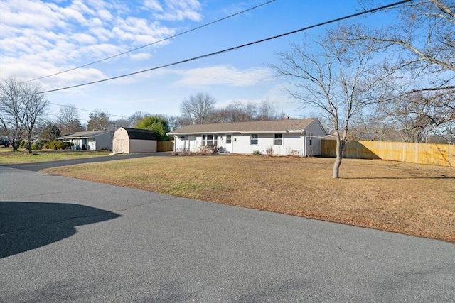 ranch-style home with a storage shed and a front yard