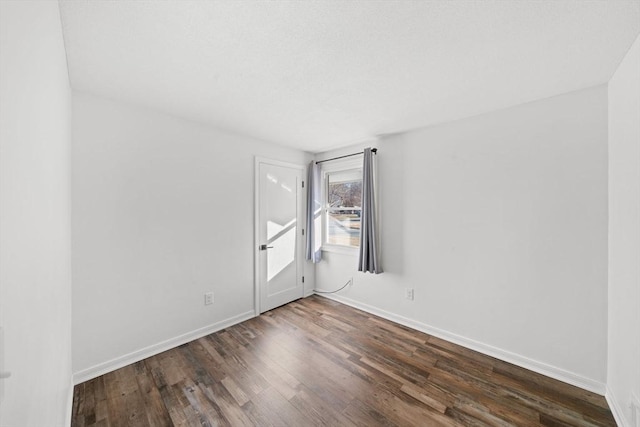 spare room with dark wood-type flooring