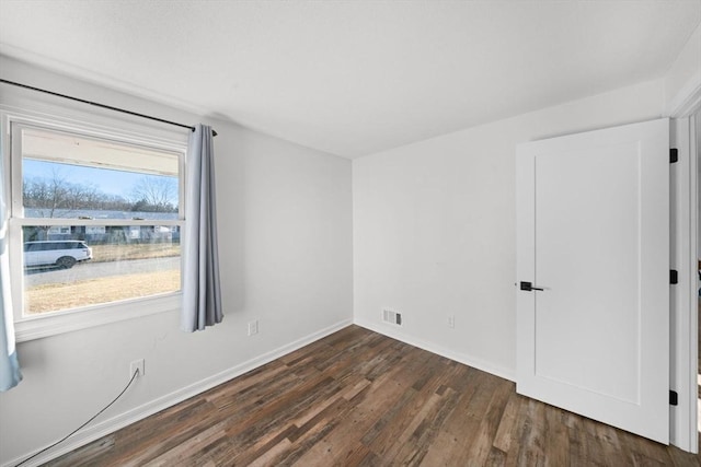 unfurnished room featuring dark wood-type flooring