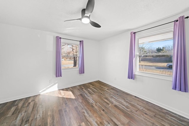 unfurnished room with dark wood-type flooring, ceiling fan, and plenty of natural light