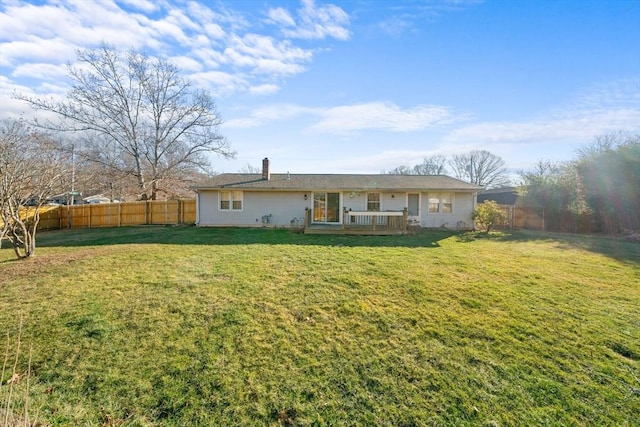 back of house with a wooden deck and a lawn