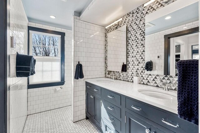 bathroom featuring a sink, tile walls, and double vanity