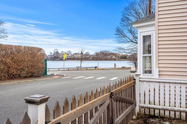 wooden deck featuring a water view and fence