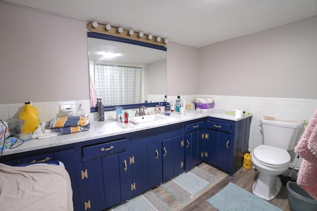 full bath with tile walls, toilet, wainscoting, wood finished floors, and vanity