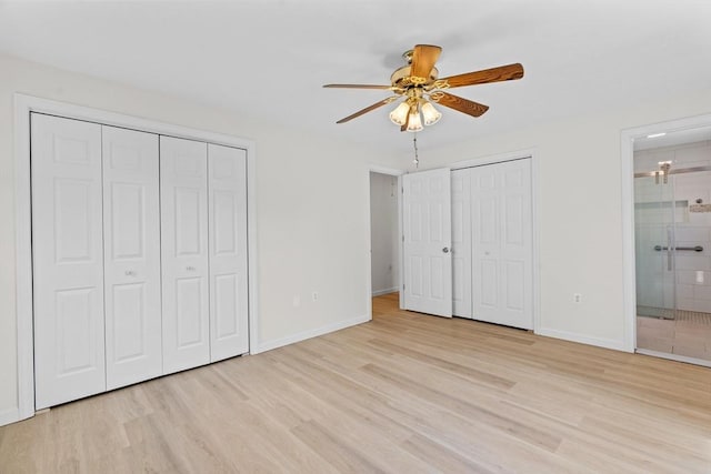447 Old Connecticut Path, Framingham, MA 01701 - unfurnished bedroom featuring two closets, light wood finished floors, baseboards, connected bathroom, and ceiling fan