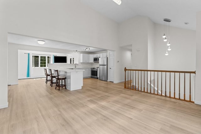 447 Old Connecticut Path, Framingham, MA 01701 - kitchen featuring appliances with stainless steel finishes, a sink, light countertops, a breakfast bar area, and white cabinets