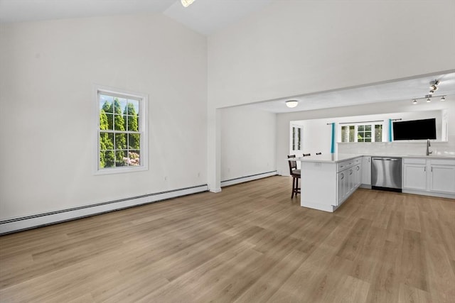 447 Old Connecticut Path, Framingham, MA 01701 - kitchen with stainless steel dishwasher, a baseboard heating unit, a kitchen bar, light wood finished floors, and a sink
