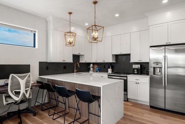 388 Athens St Unit 1, Boston, MA 02127 - kitchen featuring appliances with stainless steel finishes, a peninsula, tasteful backsplash, a kitchen bar, and a chandelier