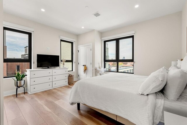 388 Athens St Unit 1, Boston, MA 02127 - bedroom with light wood finished floors, recessed lighting, and baseboards
