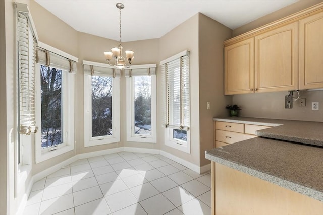 dining space with a notable chandelier, baseboards, and light tile patterned floors