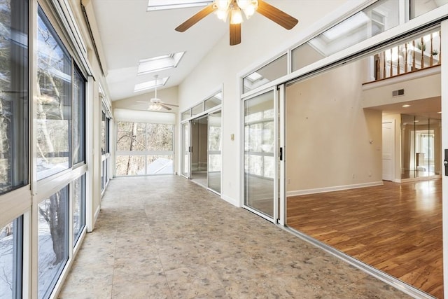 unfurnished sunroom featuring vaulted ceiling with skylight, visible vents, and ceiling fan