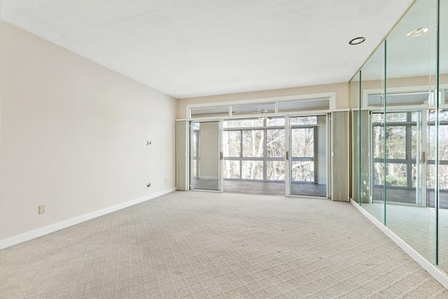 carpeted empty room featuring baseboards