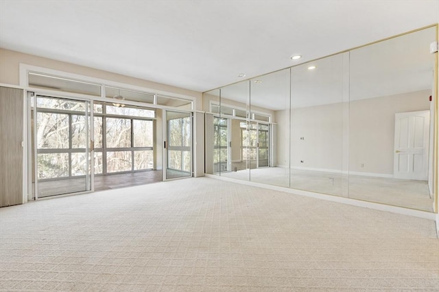 empty room with carpet floors, baseboards, and recessed lighting