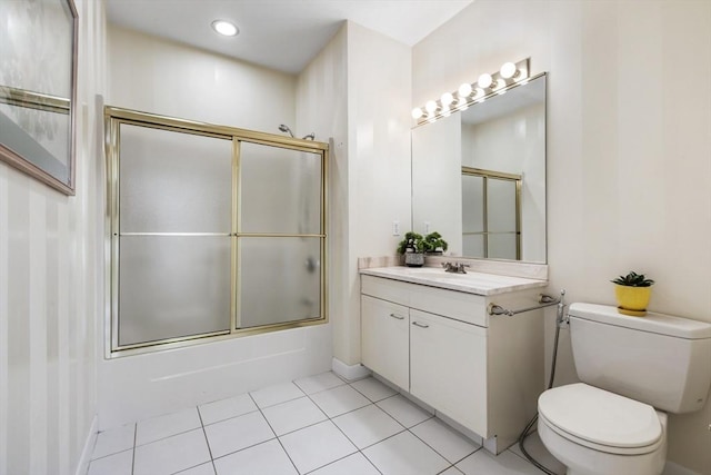 bathroom with bath / shower combo with glass door, vanity, toilet, and tile patterned floors