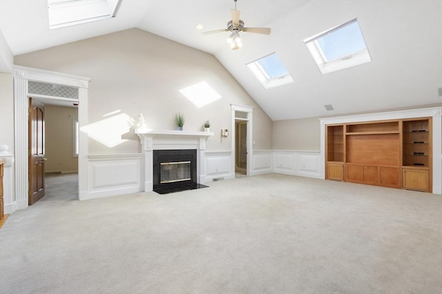 unfurnished living room featuring a decorative wall, a fireplace with flush hearth, light carpet, vaulted ceiling, and ceiling fan