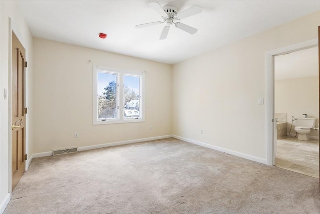 unfurnished bedroom with light carpet, visible vents, baseboards, ensuite bath, and ceiling fan